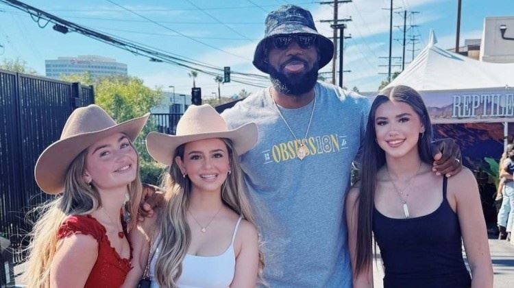 嫂子知道不？詹姆斯参加球队户外活动与三位美女合影还俏皮吐舌